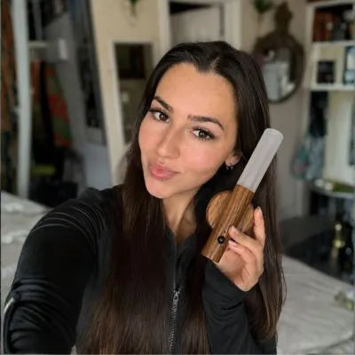 Mulher segurando a Arandela Magno mostrando o acabamento sofisticado e a luz quente aconchegante