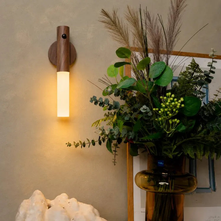 Arandela Magno instalada na parede iluminando vaso de plantas em ambiente sofisticado e aconchegante