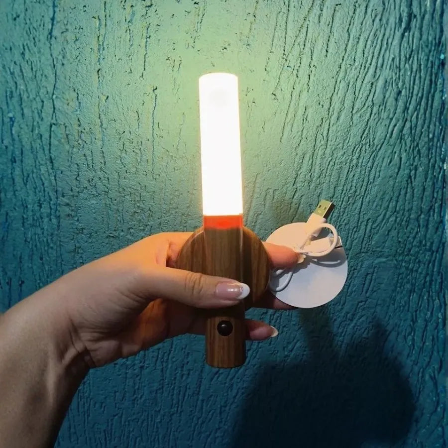 Pessoa segurando a Arandela Magno com cabo USB de carregamento destacando a praticidade da iluminação sem fio
