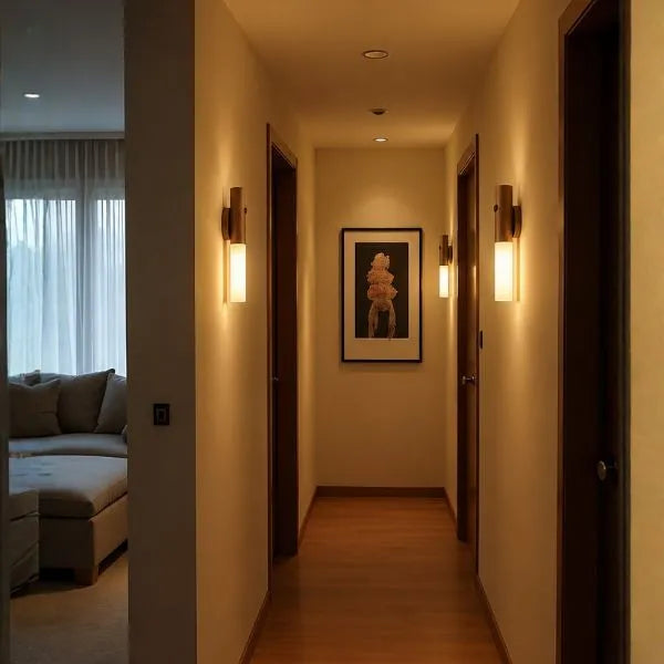 Três Arandelas Magno instaladas em corredor moderno criando iluminação elegante