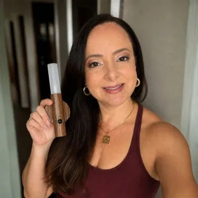 Selfie de mulher segurando a Arandela Magno com acabamento em madeira natural e iluminação elegante